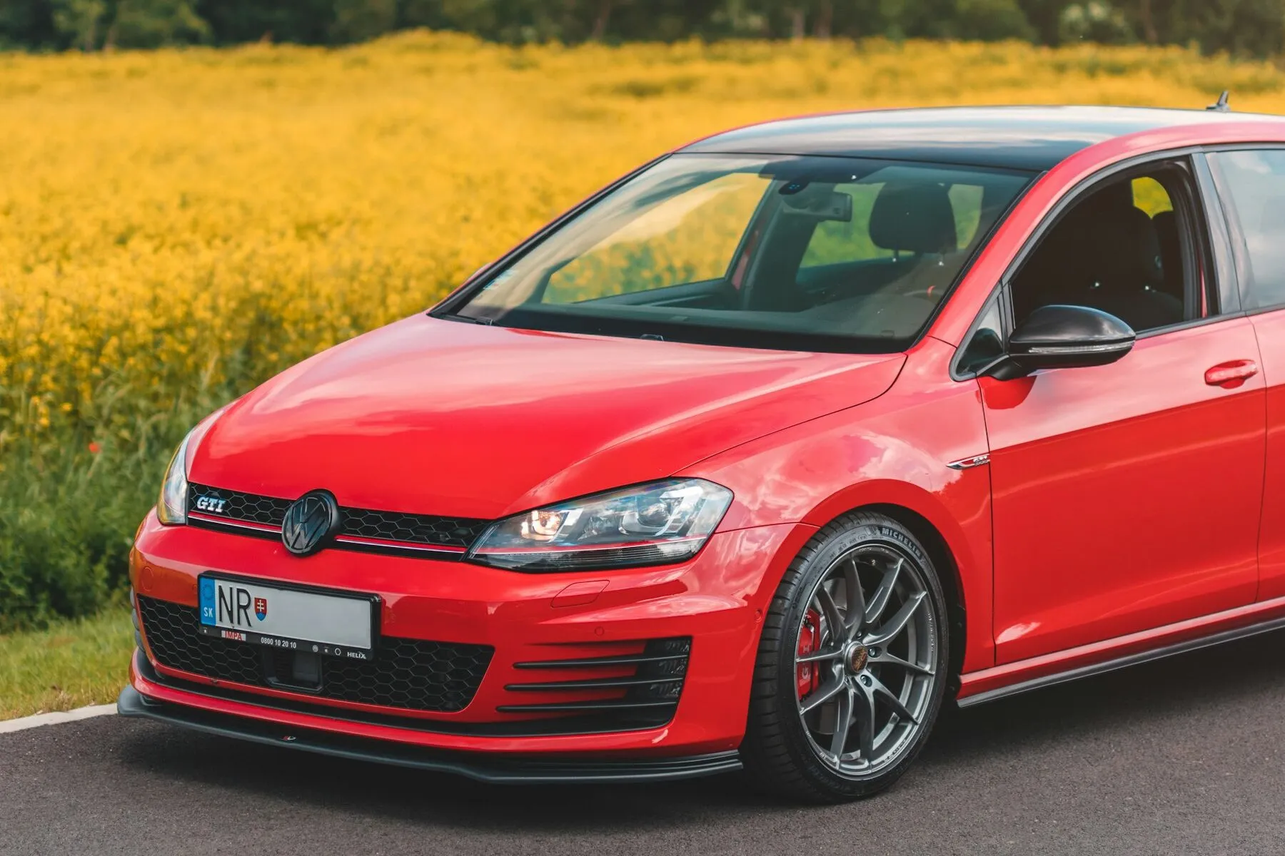 A red Volkswagen Golf GTI on an open road
